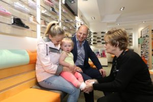 Charles Clinkard Mary Lockwood fitting shoes and one year old Hallie Walker with mum Abbey Murray lr Shoe retailer puts best foot forward with store makeover